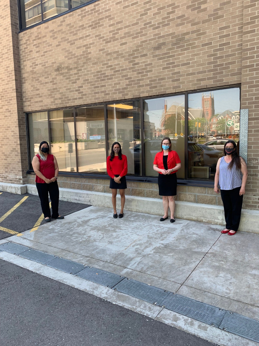 Four of the GGFI team standing in front of a wall.